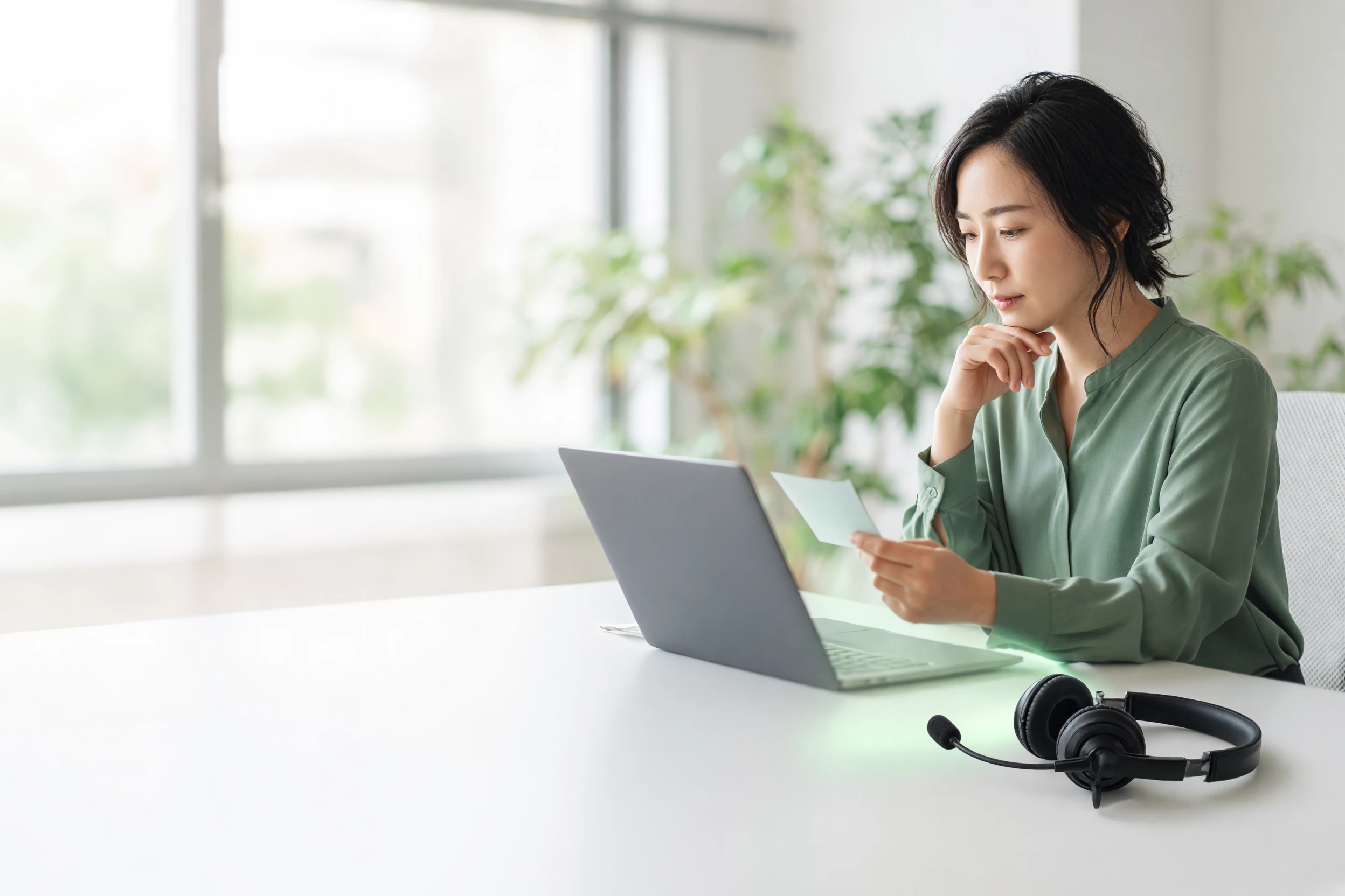 AIから引き継がれた注文内容を確認するスタッフと、机に置かれたヘッドセット
